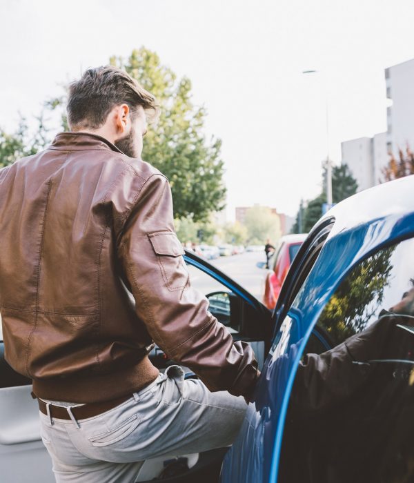 Young bearded man driving car