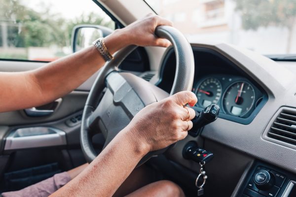 Close up of woman hands driving a car. Focus on hand